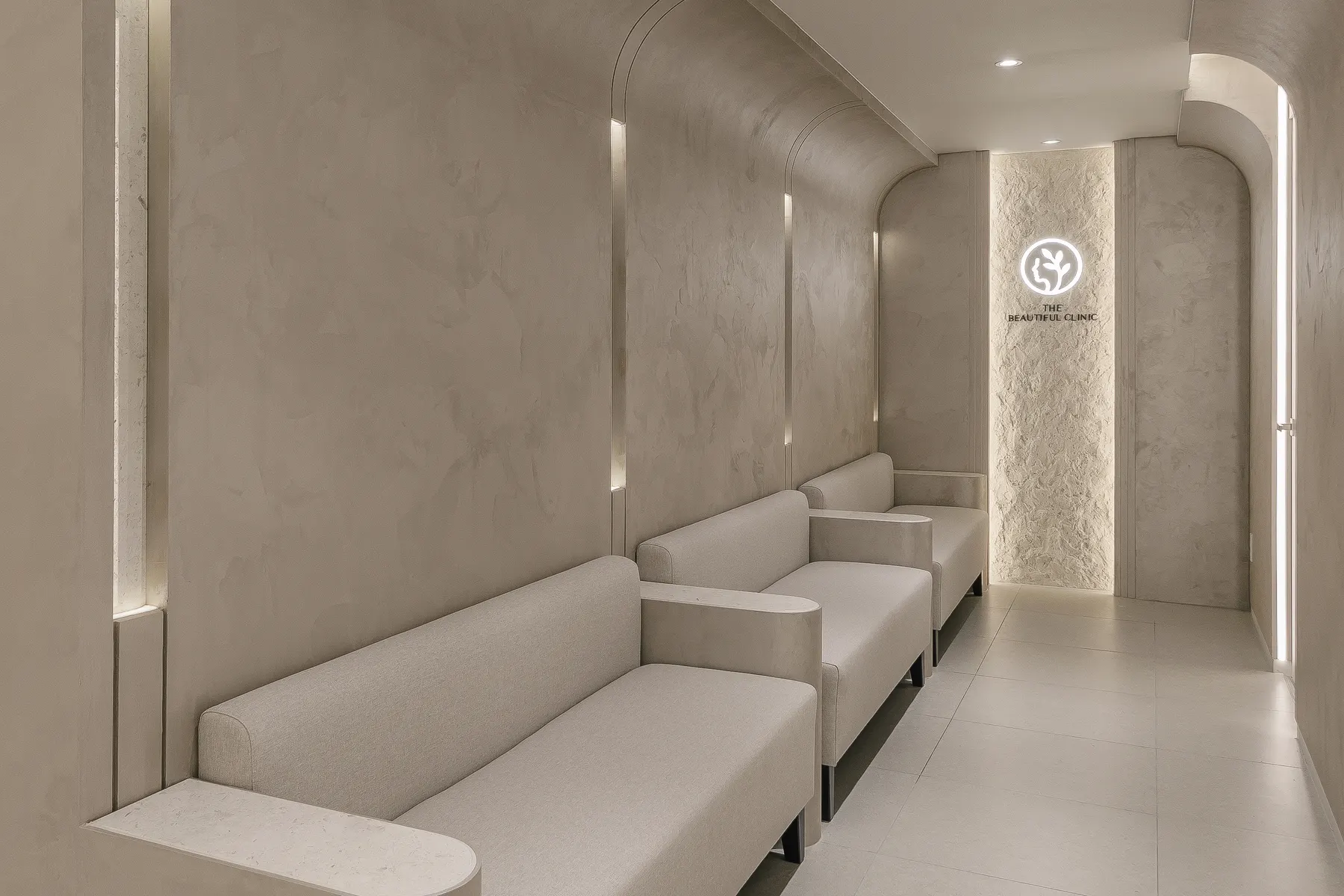 Arched corridor with seating leading to the clinic logo wall in Seoul