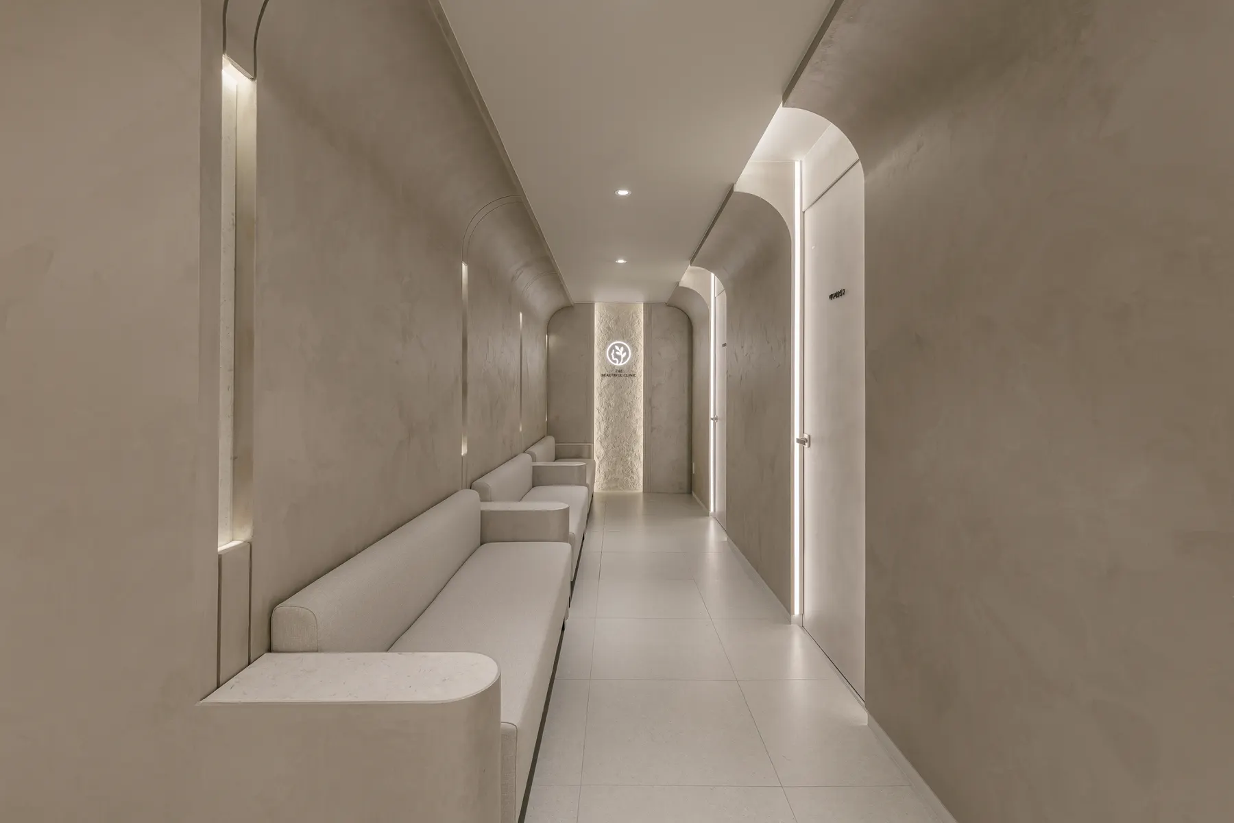 Arched waiting corridor in limestone plaster at THE Beautiful Clinic in Nonhyeon, Seoul